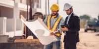 civil-engineer-construction-worker-manager-holding-digital-tablet-blueprints-talking-planing-about-construction-site-cooperation-teamwork-concept (1)